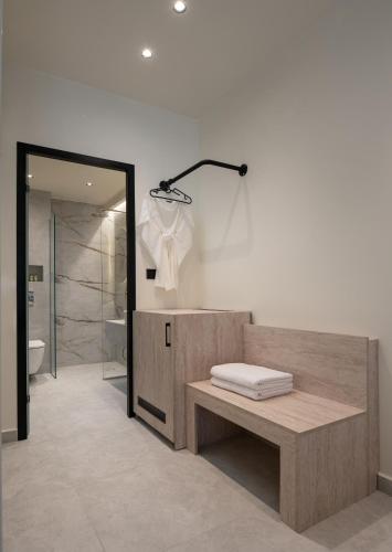 a bathroom with a bench and a sink and a shower at Phos Luxury Living in Sarti