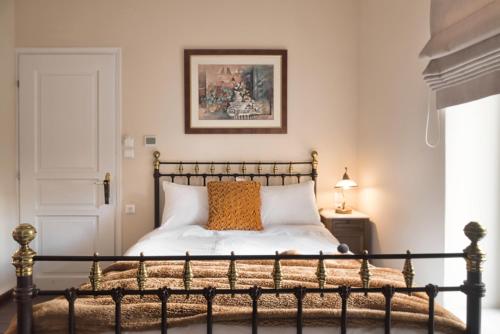 a bedroom with a bed and a picture on the wall at Αρχοντικό Ταξίμι - Ανθέων Έμπνευση in Argalasti