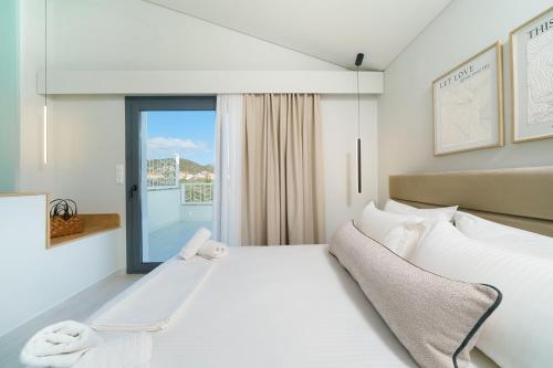 a white bedroom with a large bed and a window at Hibiscus Suites in Potos