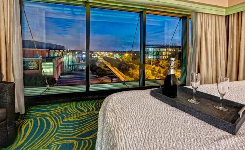 a room with a bed and a large window with wine glasses at SpringHill Suites Norfolk Old Dominion University in Norfolk