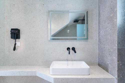 a bathroom with a sink and a mirror at Hibiscus Suites in Potos