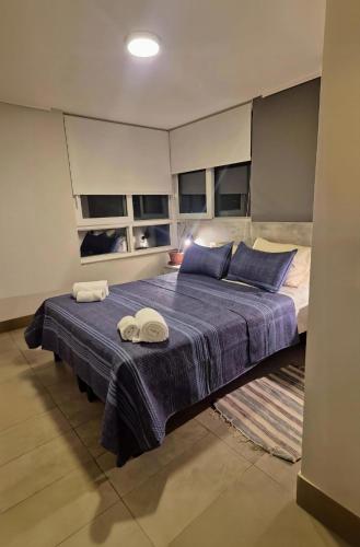 a bedroom with a bed with two towels on it at Depto cómodo y central in Temuco