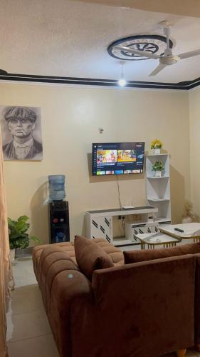 a living room with a couch and a flat screen tv at Honned homes in Mombasa