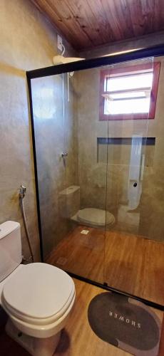 a bathroom with a toilet and a glass shower at Vila Baião - Casa Luiz Gonzaga in Itacaré