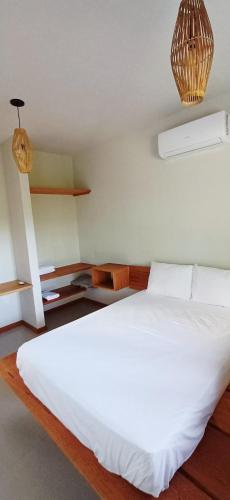 a bedroom with a large white bed in a room at Vila Baião - Casa Luiz Gonzaga in Itacaré