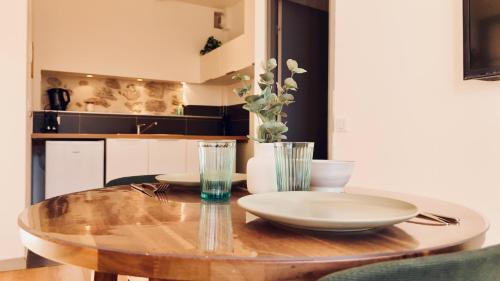 a wooden table with plates and vases on it in a kitchen at Dubonnet - Cœur de ville in Brignoles