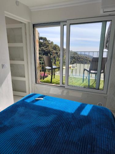 a bedroom with a bed and a large window at Maison vue mer a 5 min de MONACO in Roquebrune-Cap-Martin