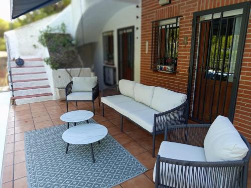 a porch with a couch and two chairs and a table at Casa Azahar in Lliria