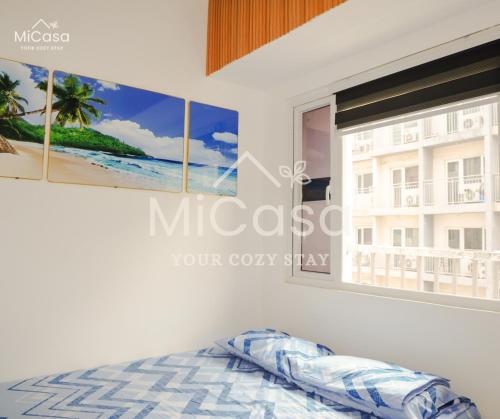 a bedroom with a window with a view of the beach at MiCasa South Residences Cozy & Affordable Stay in Manila