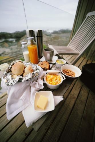 a table with breakfast foods and drinks on a balcony at Hotel 8 al Mar in Pichilemu