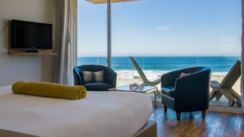 a bedroom with a bed and a view of the ocean at Hotel 8 al Mar in Pichilemu