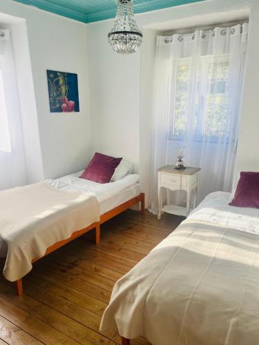 a bedroom with two beds and a chandelier at B&B by the River Beach in Mega Fundeira