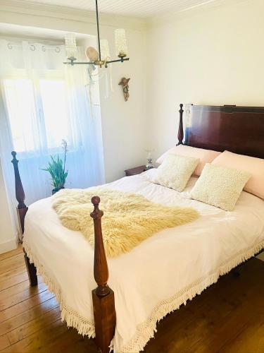 a bedroom with a large bed with a wooden headboard at B&B by the River Beach in Mega Fundeira