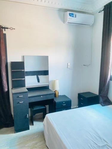 a bedroom with a bed and a desk with a mirror at Amie's Villa Apartment in Jarbang