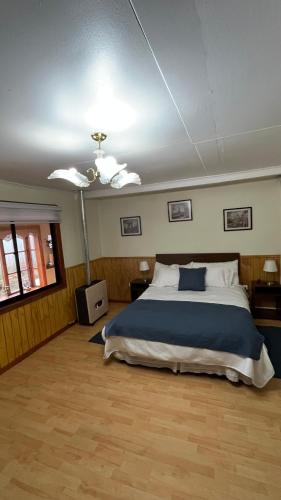 a bedroom with a large bed and a ceiling fan at MI HOGAR ES TUYO in Punta Arenas