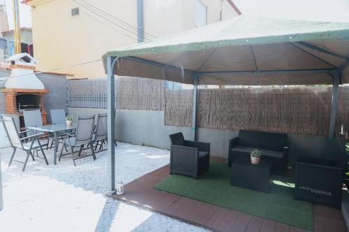 a gazebo with chairs and tables and a table and chairs at Villa Frescura do Mar by Casas de Setúbal in Setúbal