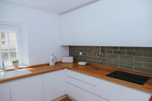 a kitchen with white cabinets and a sink at Villa Frescura do Mar by Casas de Setúbal in Setúbal