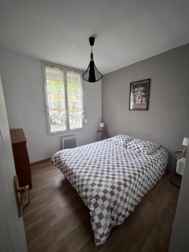 a bedroom with a bed with a checkered blanket at Villa Juliette in Le Tréport