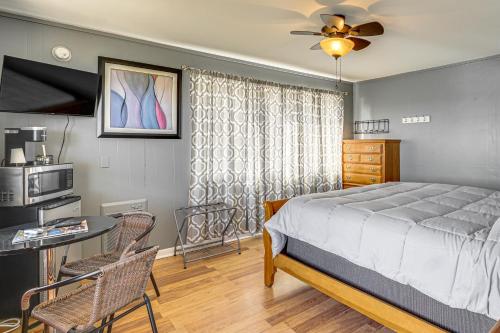 a bedroom with a bed and a table and a microwave at Lake Ozark Stay for Shootout Weekend in Lake Ozark