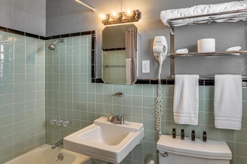 a bathroom with a sink and a toilet and a mirror at Lake Ozark Stay for Shootout Weekend in Lake Ozark