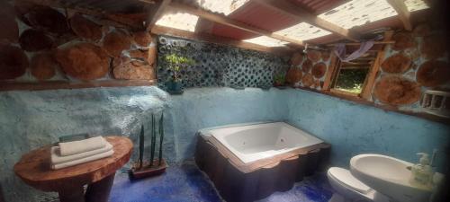 a bathroom with a tub and a toilet and a sink at Bosque de Oro in Apía
