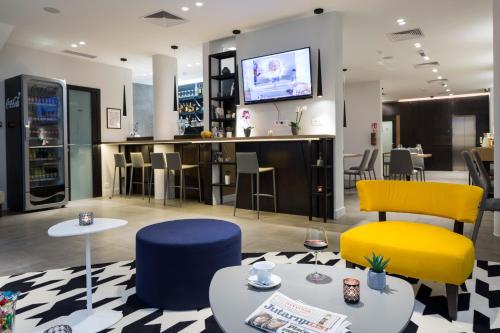 a cafe with colorful chairs and a bar at Livris Hotel in Zagreb
