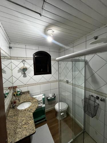 a bathroom with a sink and a toilet at Casa Conforto & Lazer Foz do Iguaçu in Foz do Iguaçu