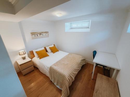 a small bedroom with a bed and a desk at Villa Frescura do Mar by Casas de Setúbal in Setúbal