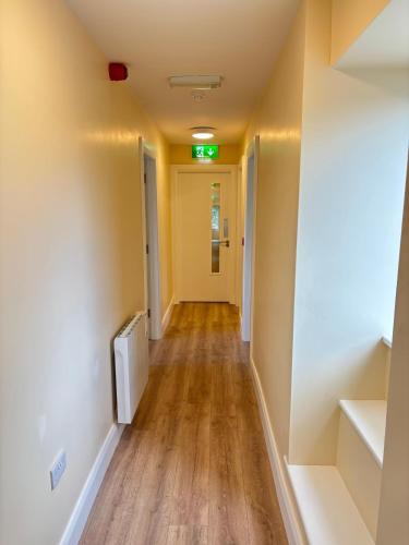 Glancy's Accommodation في كاريك اُن شانون: ممر في غرفة فارغة ذات أرضيات خشبية