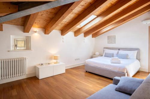 a bedroom with a bed and a couch and wooden ceilings at Apartments Trieste Centro I 2 in Trieste