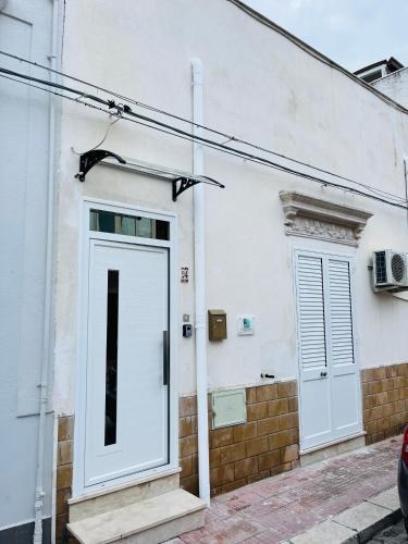 a white building with a door on the side of it at Ocean's Holiday House in Terrasini