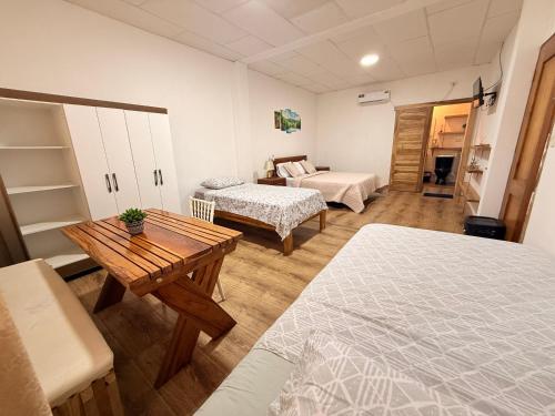 a room with two beds and a table in it at ROOM AYAMPE - La Casa de Eros in Ayampe