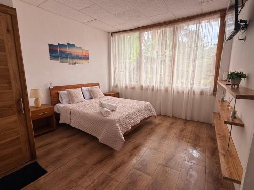 a bedroom with a bed and a large window at ROOM COLIBRÍ - La Casa de Eros in Ayampe