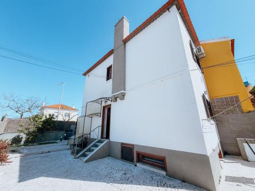 a white building with a staircase on the side of it at Villa Frescura do Mar by Casas de Setúbal in Setúbal