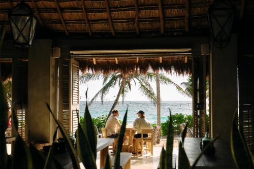two people sitting at a table looking out at the beach at Hotel Panamera in Tulum