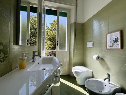 a bathroom with a sink and a toilet and a window at Casa Melina - Pesaro Mare in Pesaro