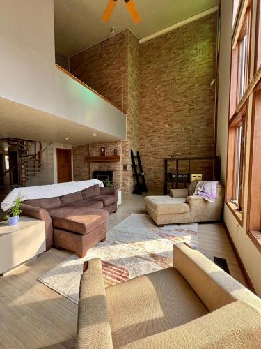 ein großes Wohnzimmer mit einem Bett und einer Couch in der Unterkunft Falling Timber- A Frank Lloyd Wright Inspired Staycation in Canton