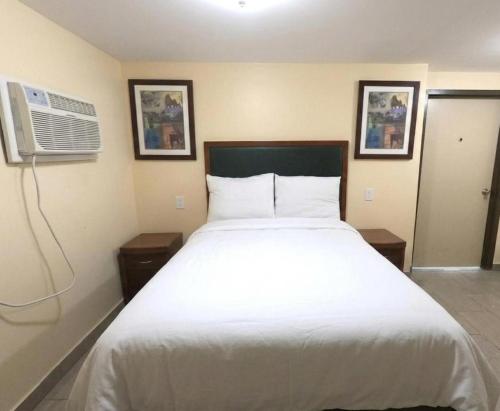 a bedroom with a white bed and a air conditioner at GG Rest-Inn in Elizabeth