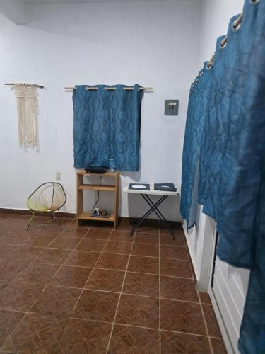 a room with blue curtains and a tiled floor at Estudio Mar in Brisas de Zicatela
