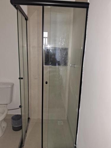 a glass shower in a bathroom with a toilet at Pousada Paula Lima I in Juiz de Fora