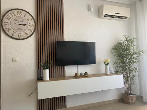 a living room with a tv on a wall at Edificio TORREMAR vistas al mar, orientación norte, Wifi y Smart-TV in Oropesa del Mar