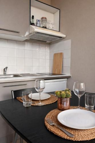 a kitchen with two plates and glasses on a counter at LE 139 carcassonne in Carcassonne