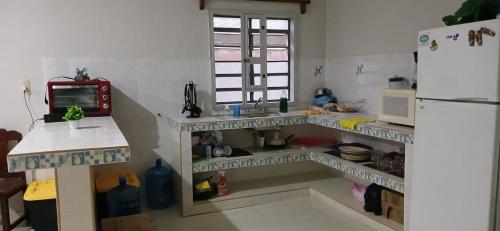 a kitchen with a counter and a refrigerator at Villa Prix in Hunucmá
