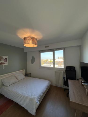 a bedroom with a bed and a desk and a window at Appartement moderne avec parking privé Lit connecté LED & rétroprojecteur 5 min Zénith in Saint-Herblain