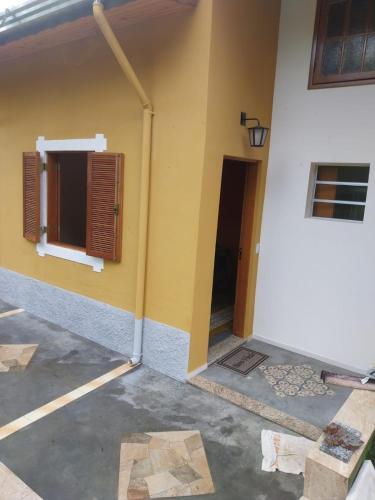 a side of a building with a door and a window at Recanto do Ipê in Extrema