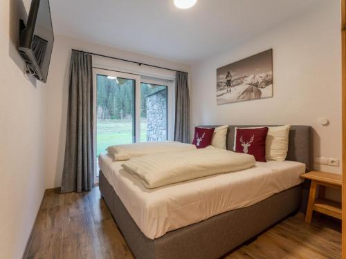 a large bed in a room with a window at Pinzgau Lodge 2B in Wald im Pinzgau