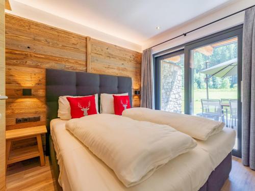 a bedroom with a large bed with red pillows at Pinzgau Lodge 1A in Wald im Pinzgau