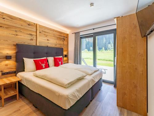 a bedroom with a large bed and a large window at Pinzgau Lodge 1B in Wald im Pinzgau