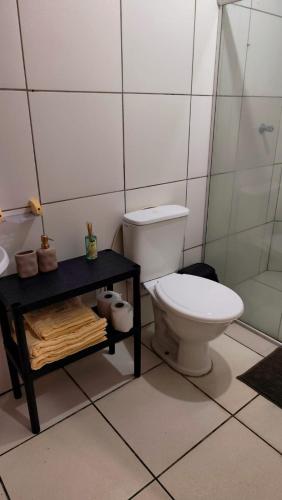 a white bathroom with a toilet and a table at Casa 89 in Itacaré