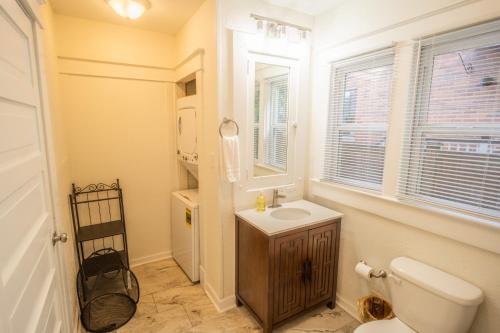 a bathroom with a toilet and a sink and a window at Walk to Duke Campus! 3 Bedroom in Trinity Park! in Durham